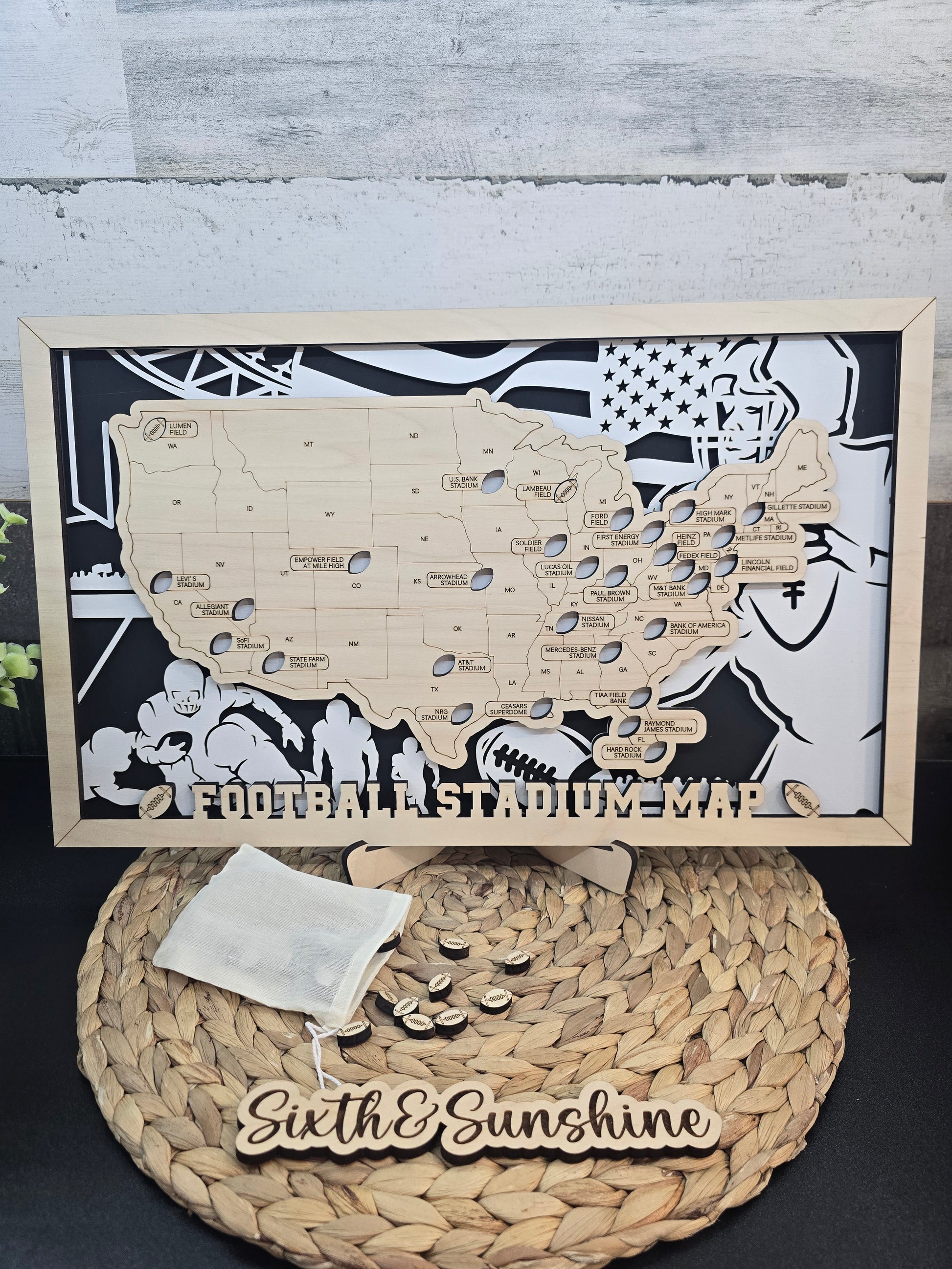 Framed Stadium Series Football Map by Sixth & Sunshine, shown with a bag of removable stadium markers ready to be placed on the map